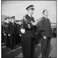 Un lieutenant de vaisseau lit l'ordre du jour lors d'une cérémonie présidée par Louis Jacquinot, ministre de la Marine.