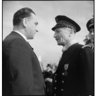 Louis Jacquinot, ministre de la Marine, félicite le contre-amiral Robert Jaujard auquel il vient de remettre l'insigne de commandeur de la Légion d'honneur lors d'une cérémonie à bord d'un bâtiment.