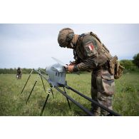 Un droniste du 61e régiment d'artillerie (RA) assemble un système de mini-drone de reconnaissance (SMDR) sur sa rampe de lancement et de catapultage d'à Tapa, en Estonie.