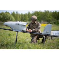 Un droniste du 61e régiment d'artillerie (RA) assemble un système de mini-drone de reconnaissance (SMDR) sur sa rampe de lancement et de catapultage d'à Tapa, en Estonie.