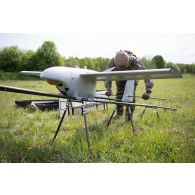 Un droniste du 61e régiment d'artillerie (RA) assemble un système de mini-drone de reconnaissance (SMDR) sur sa rampe de lancement et de catapultage d'à Tapa, en Estonie.