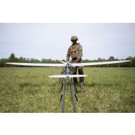 Un droniste du 61e régiment d'artillerie (RA) installe un système de mini-drone de reconnaissance (SMDR) sur sa rampe de lancement et de catapultage d'à Tapa, en Estonie.