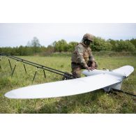 Un droniste du 61e régiment d'artillerie (RA) installe un système de mini-drone de reconnaissance (SMDR) sur sa rampe de lancement et de catapultage d'à Tapa, en Estonie.