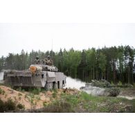 Un blindé à roues et canon rénové AMX-10 RCR du 1er régiment étranger de cavalerie (REC) manoeuvre aux côtés d'un char Challenger 2 britannique à Tapa, en Estonie.