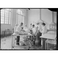 Ambulance américaine de Neuilly, salle d’opérations, le Dr Dubouchet opère un blessé. [légende d’origine]