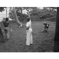 [Séance photo. Un photographe assisté d'un homme tenant un projecteur prend une photo, s.d.].<br>