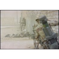 Des marsouins du 3e RIMa (régiment d'infanterie de marine) investissent la ville d'Al Salman, postés à l'angle d'une rue. Ils ne portent pas de S-3P (survêtement de protection à port permanent) NBC (risque nucléaire, bactériologique et chimique). Un Apilas est visible dans le dos d'un marsouin.