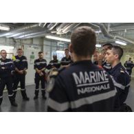 Des soldats de l'équipe d'intervention participent à un briefing au terme d'un exercice incendie à bord du porte-hélicoptères amphibie (PHA) Tonnerre en mer Méditerranée.