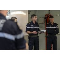 Un capitaine de vaisseau participe à un briefing auprès des soldats de l'équipe d'intervention au terme d'un exercice incendie à bord du porte-hélicoptères amphibie (PHA) Tonnerre en mer Méditerranée.