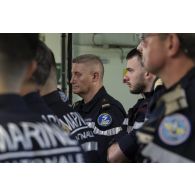 Des soldats de l'équipe d'intervention participent à un briefing au terme d'un exercice incendie à bord du porte-hélicoptères amphibie (PHA) Tonnerre en mer Méditerranée.