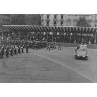 Défilé à pied. Passage du drapeau et sa garde du1er groupe de chasseurs mécanisés (1er GCM) de Reims devant la tribune présidentielle lors de la cérémonie du 14 juillet 1974 sur la place de la Bastille.
