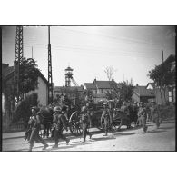 Des soldats britanniques de la BEF marchent en colonne dans une rue d'un village minier du département du Nord.