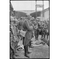 En gare de Sidi Bel-Abbés, les légionnaires du 1er REI mangent en attendant le départ.