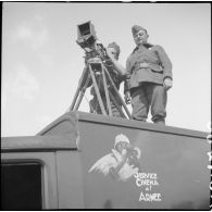 Un opérateur de prise de vue du SCA et son aide sont photographiés sur le toit du camion SCA immatriculé Z757207 en contre-plongée lors d'un tournage au fort du Télegraphe, sous le col du Galibier.