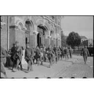 Des prisonniers alliés passent devant la gare du Cambrésis à Cambrai.