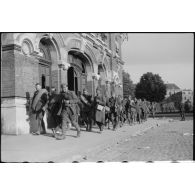 Des prisonniers alliés passent devant la gare du Cambrésis à Cambrai.