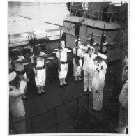 Dans le port de Saigon, lors d'une visite aux avisos "Le Chevreuil" et "La Gazelle" et à la frégate                  "Le Tonkinois", l'amiral Thierry d'Argenlieu passe en revue et salue les troupes embarquées sur l'un des bâtiments. [description provisoire]