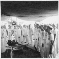 Dans le port de Saigon, lors d'une visite aux avisos "Le Chevreuil" et "La Gazelle" et à la frégate                  "Le Tonkinois", l'amiral Thierry d'Argenlieu passe en revue les troupes embarquées sur l'un des bâtiments. [description provisoire]