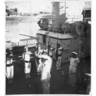 Dans le port de Saigon, lors d'une visite aux avisos "Le Chevreuil" et "La Gazelle" et à la frégate                  "Le Tonkinois", l'amiral Thierry d'Argenlieu passe en revue et salue les troupes embarquées sur l'un des bâtiments. [description provisoire]