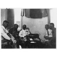 Lors de la réception  général Leclerc au palais présidentiel, (de gauche à droite) Jean Cédile, Nguyen Van Xuan, l'amiral Thierry d'Argenlieu, le colonel Nguyen Van Thinh et le général Leclerc discutent autour d'une table. [description provisoire]