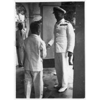 Lors de sa réception au palais du président Thinh, l'amiral britannique Archer est accueilli par le président du Gouvernement provisoire de la Cochinchine, Nguyen Van Thinh et par un représentant de l'autorité française. [description provisoire]