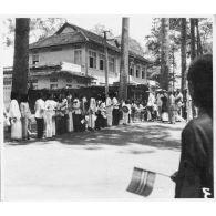 La population de de Thu Dau Mot se presse dans les rues, pour venir voir l'amiral Thierry d'Argenlieu, lors de sa visite officielle de la ville. [description provisoire]