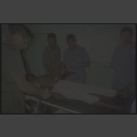Intervention et opération chirurgicale sur un patient blessé à la main dans un dispensaire à Karama par les membres de l'antenne chirurgicale parachutiste (ACP).