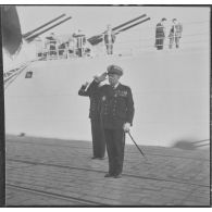 Alger. L'amiral Barthélémy salue l'étendard de la Marine Nationale.