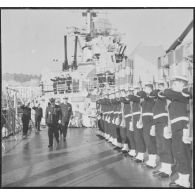 Alger. Une haie d'honneur présente les armes à l'amiral Barthélémy à bord du croiseur De Grasse (C610).