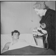 Alger. Arbre de Noël à l'hôpital Maillot. Remise de cadeaux à un grand blessé par madame Ailleret.