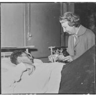 Alger. Arbre de Noël à l'hôpital Maillot. Remise de cadeaux à un grand blessé par madame de Menditte.