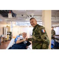 Le général Thierry Burckhard échange avec un blessé pour un exercice sanitaire à l'hôpital du porte-hélicoptères amphibie (PHA) Tonnerre à Sète.