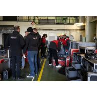 Des techniciens de l'ECPAD installent du matériel audiovisuel à bord du porte-hélicoptèress amphibie (PHA) Tonnerre à Sète.