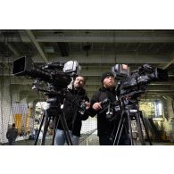 Les opérateurs vidéos Sébastien et Quentin de l'ECPAD règlent leur caméra à bord du porte-hélicoptèress amphibie (PHA) Tonnerre à Sète.