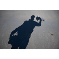 L'opérateur de prise de vues Olivier de l'ECPAD prend son ombre en photographie à bord du porte-hélicoptèress amphibie (PHA) Tonnerre à Sète.