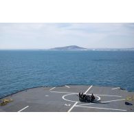 Des techniciens audiovisuels installent une antenne satellite sur le pont d'envol du porte-hélicoptèress amphibie (PHA) Tonnerre à Sète.