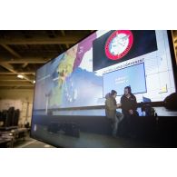 L'opérateur vidéo Simon de l'ECPAD se coordonne avec un technicien audiovisuel à bord du porte-hélicoptèress amphibie (PHA) Tonnerre à Sète.