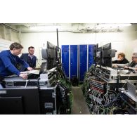 Le réalisateur-en-chef Maxence de l'ECPAD travaille avec des techniciens audiovisuels à bord du porte-hélicoptèress amphibie (PHA) Tonnerre à Sète.