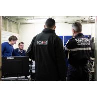 Le réalisateur-en-chef Maxence et l'officier image Maxime de l'ECPAD se coordonnent avec le contre-amiral Cédric Chetaille à bord du porte-hélicoptèress amphibie (PHA) Tonnerre à Sète.