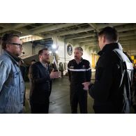 Le réalisateur-en-chef Maxence et l'officier image Maxime de l'ECPAD se coordonnent avec le contre-amiral Cédric Chetaille à bord du porte-hélicoptèress amphibie (PHA) Tonnerre à Sète.