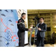 Le réalisateur-en-chef Maxence de l'ECPAD se coordonne avec le contre-amiral Cédric Chetaille à bord du porte-hélicoptèress amphibie (PHA) Tonnerre à Sète.