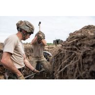 Un sapeur de marine du 6e régiment du génie (RG) et un soldat des Royal Engineers creusent une tranchée à Tapa, en Estonie.