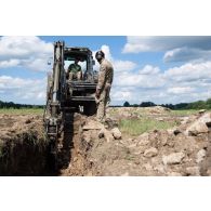 Des soldats britanniques des Royal Engineers creusent une tranchée au moyen d'un bulldozer light wheeled tractor (LWT) à Tapa, en Estonie.