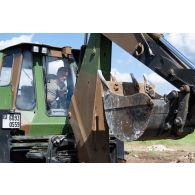 Un sapeur de marine du 6e régiment du génie (RG) pilote un engin rapide de protection et d'appui (EGRAP) pour creuser une tranchée à Tapa, en Estonie.