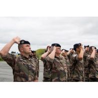 Le capitaine Baptiste de l'élément de soutien national (ESN) salue le lever des couleurs en tête de sa compagnie pour la cérémonie du 14 juillet à Tapa, en Estonie.