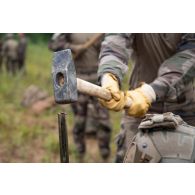 Un sapeur de marine du 6e régiment du génie (RG) plante un piquet pour la construction d'un réseau de fil barbelé à Tapa, en Estonie.
