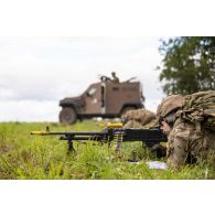 Une section de soldats britanniques progresse sous la protection d'un petit véhicule protégé (PVP) à Tapa, en Estonie.