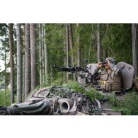 Le soldat de 1re classe Tukus du régiment d'infanterie-chars de marine (RICM) observe le secteur en trappe d'un blindé à roues et canon AMX-10 RC en forêt de Tapa, en Estonie.