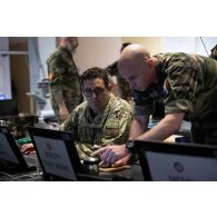 Un soldat du corps de réaction rapide-France (CRR-FR) collabore avec son homologue britannique au poste de commandement de l'exercice Orion 4 à Mailly-le-Camp.