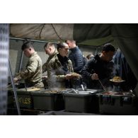 Des soldat britanniques prennent leur repas à l'ordinaire du camp du Royal Logistic Corps à Vouziers.